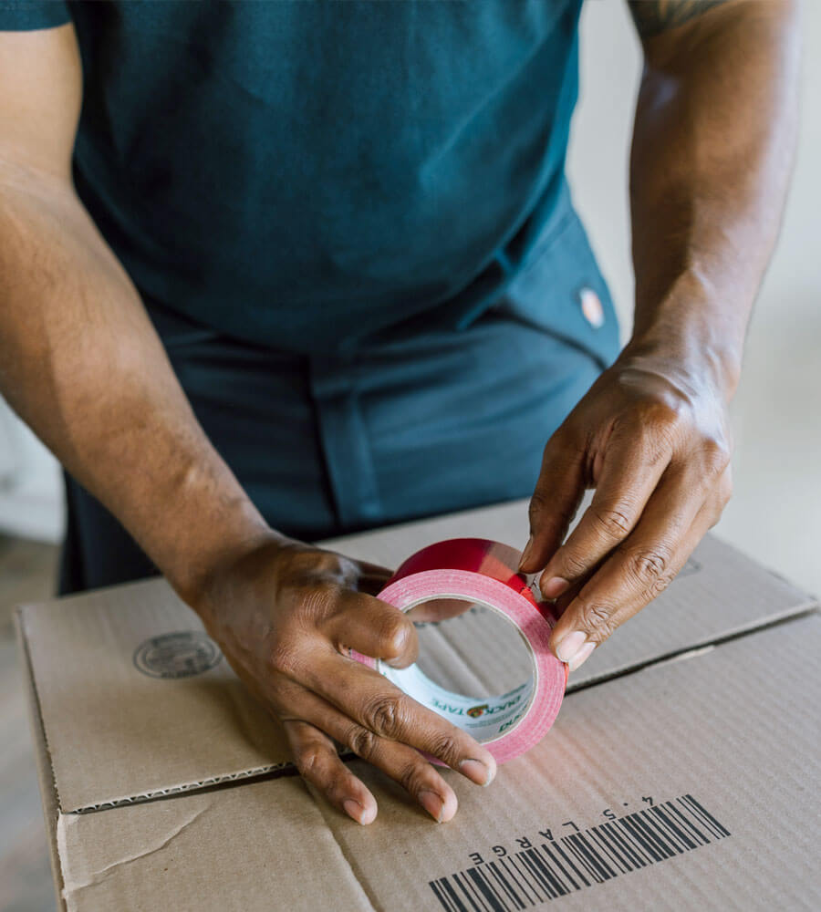 Picture of a cleaner taping a box