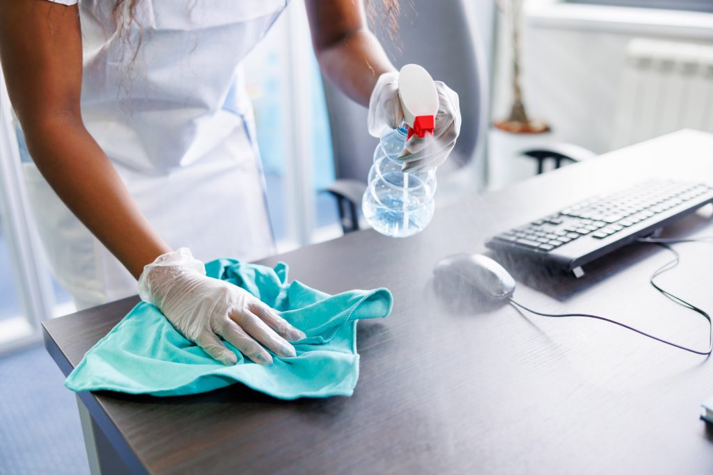 Female worker cleaning a desk with eco friendly products